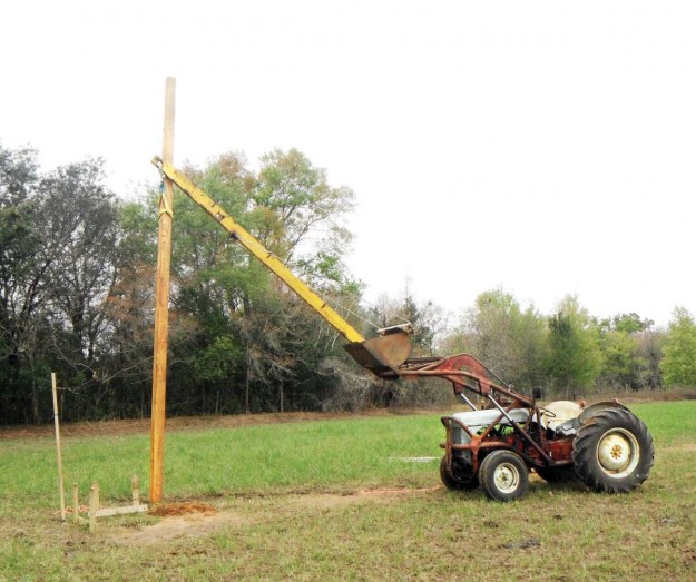 Pole barn with an 8N truss boom setting a pole